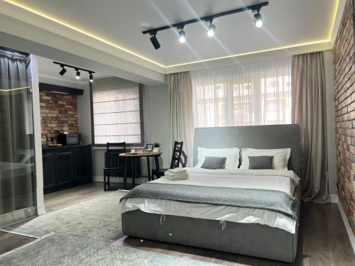 a bedroom with a large bed and a kitchen at Студия в современном стиле in Pavlodar