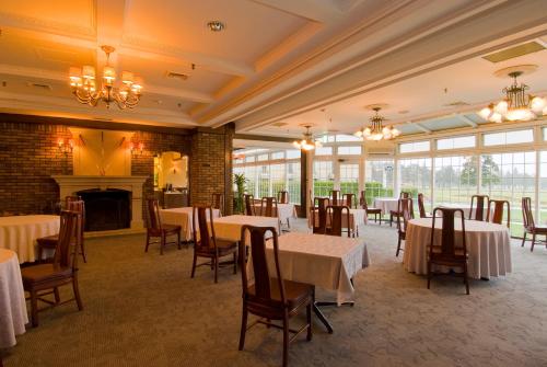a dining room with tables and chairs and a fireplace at Wellness Forest Nasu in Nasu