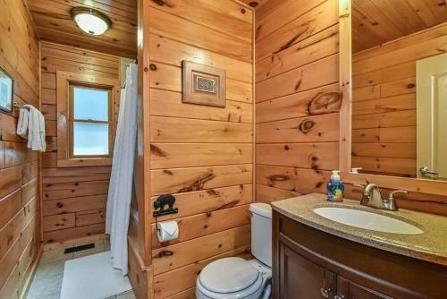 a log cabin bathroom with a toilet and a sink at Spectacular Log Cabin Home 45 minutes to Asheville in Marion