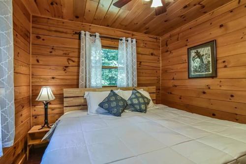 een slaapkamer met een bed in een blokhut bij Spectacular Log Cabin Home 45 minutes to Asheville in Marion