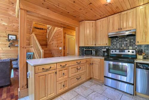 a kitchen with wooden cabinets and a stove top oven at Spectacular Log Cabin Home 45 minutes to Asheville in Marion