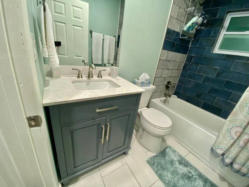 a bathroom with a sink and a toilet and a tub at Serene renovated oasis near downtown area in Gainesville