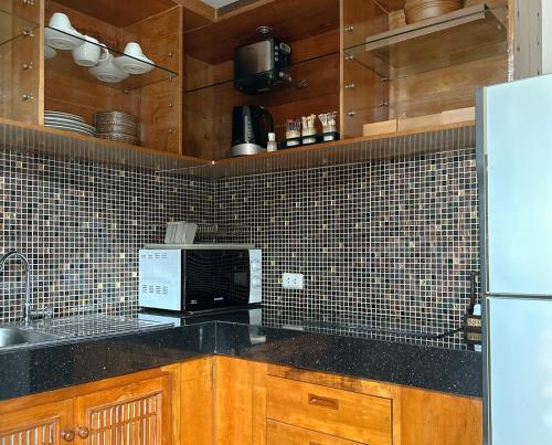 a kitchen with a black counter top and a refrigerator at Korsiri Pool Villas in Panwa Beach