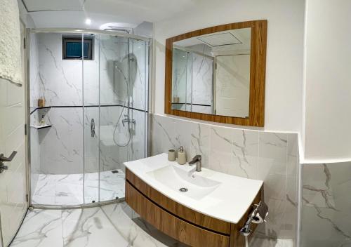 a bathroom with a shower and a sink and a mirror at Tourist Inn Grand in Male City