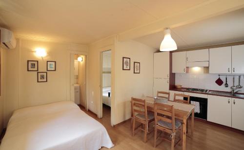 a bedroom with a bed and a table and a kitchen at Il Frantoio Camping in San Bartolomeo al Mare