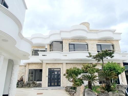 a large white building with a black door at White Castle Pension in Jeju