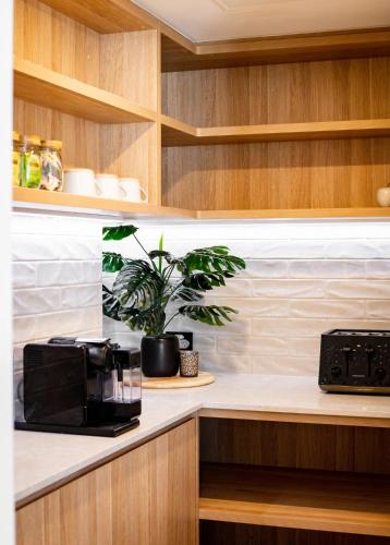 a kitchen with a black microwave and a plant on a counter at BreakFree Royal Harbour in Cairns