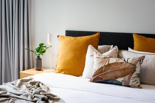 a bed with yellow and white pillows on it at BreakFree Royal Harbour in Cairns