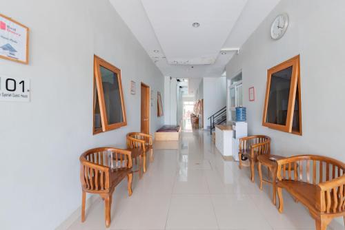 a hallway with chairs and a clock on the wall at RedDoorz Syariah near DPRD Kabupaten Subang in Subang