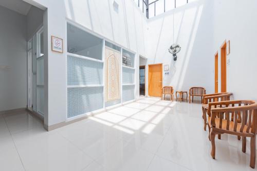 a room with chairs and a table and a window at RedDoorz Syariah near DPRD Kabupaten Subang in Subang