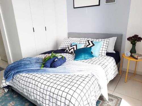 a bedroom with a bed with blue and white pillows at Horizon Suites Near KLIA Airport (B) in Sepang