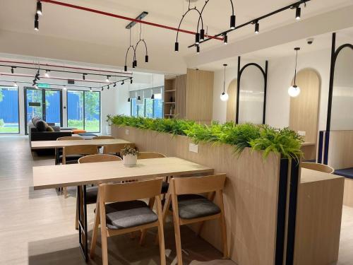 a restaurant with tables and chairs and plants at Horizon Suites Near KLIA Airport (B) in Sepang