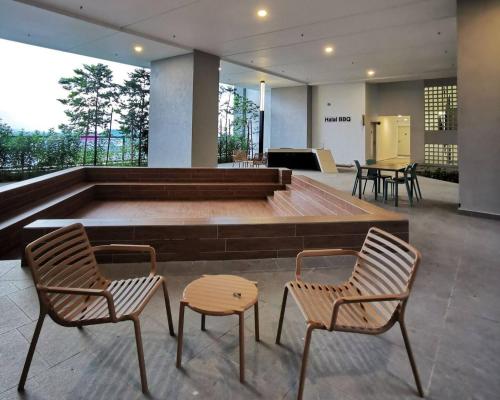 a large pool with two chairs and a table at Horizon Suites Near KLIA Airport (B) in Sepang