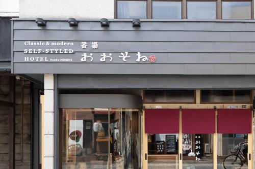 a building with a sign for a hotel at Classic ＆ modern SELF-STYLED HOTEL 番場おおそね in Chichibu