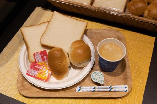 a plate of sandwiches and a cup of coffee on a table at Classic ＆ modern SELF-STYLED HOTEL 番場おおそね in Chichibu