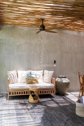 a couch sitting in a room with a ceiling at Amaka Villas in Uluwatu