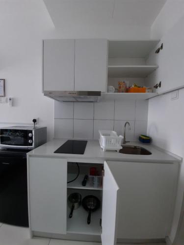 a small kitchen with white cabinets and a sink at Horizon Suites Near KLIA Airport (B) in Sepang