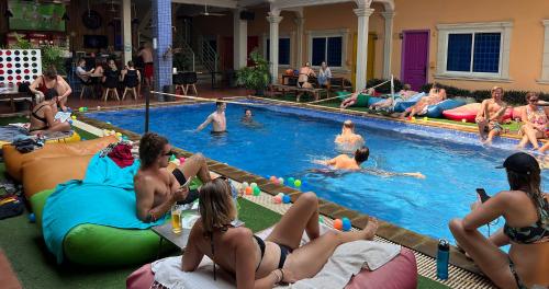 un groupe de personnes assises dans une piscine dans l'établissement The Funky Village, à Siem Reap