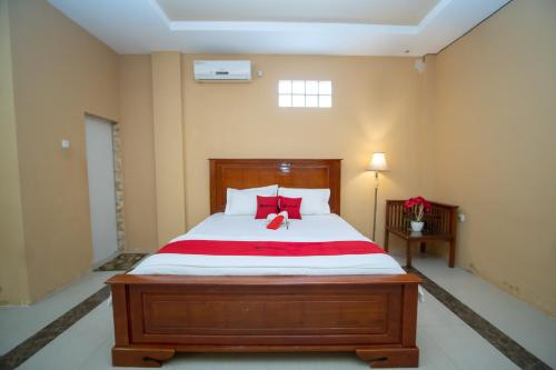 a bedroom with a large bed with red pillows at RedDoorz Syariah @ Jalan Gajah Mada Meulaboh in Meulaboh