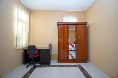 a room with a desk and a chair and a door at RedDoorz Syariah @ Jalan Gajah Mada Meulaboh in Meulaboh