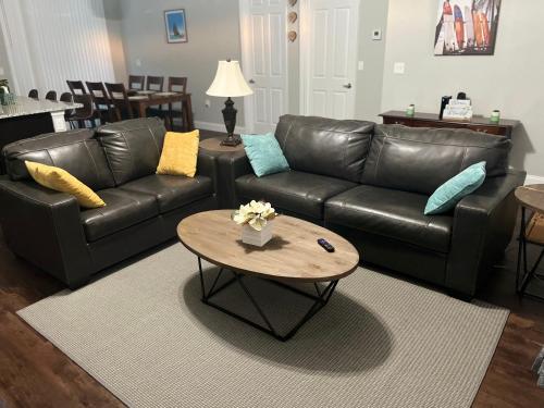 ein Wohnzimmer mit einem Ledersofa und einem Couchtisch in der Unterkunft Perfect Getaway Home! Close to Rainbow Springs! in Citrus Springs