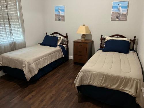 ein Schlafzimmer mit 2 Betten und eine Kommode mit einer Lampe in der Unterkunft Perfect Getaway Home! Close to Rainbow Springs! 