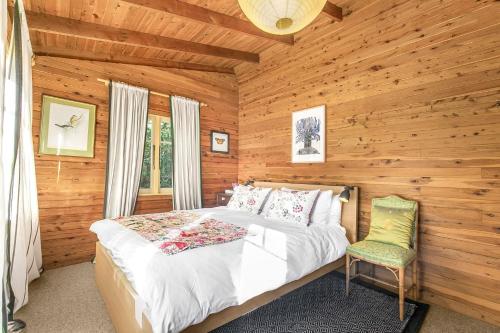 a bedroom with a bed and a chair in a cabin at Cooee Cottage in Blackheath