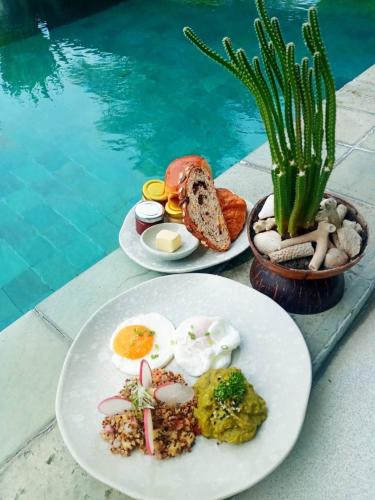 two plates of breakfast food next to a swimming pool at The Beach Samui in Taling Ngam Beach