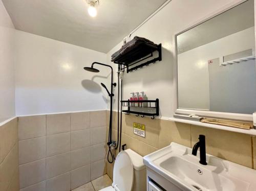 bagno con lavandino, servizi igienici e specchio di The Red Room 2bed room Condo a Imus