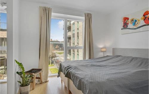 a bedroom with a bed and a large window at Gorgeous Home In Kbenhavn S With Kitchen in Copenhagen