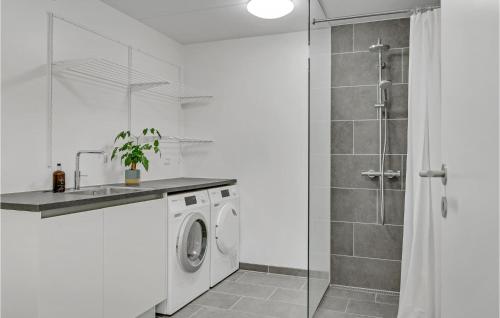 uma casa de banho branca com uma máquina de lavar roupa e um chuveiro em Gorgeous Home In Kbenhavn S With Kitchen em Copenhaga