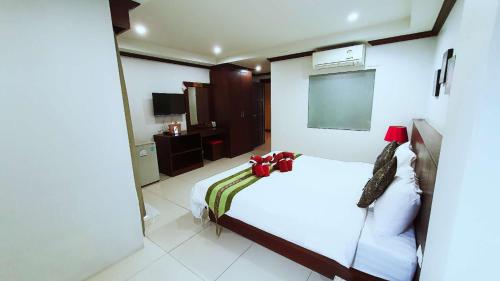 a bedroom with a white bed and a tv at Nanai 8 Road 芭东一卧豪华公寓位置便利 in Patong Beach