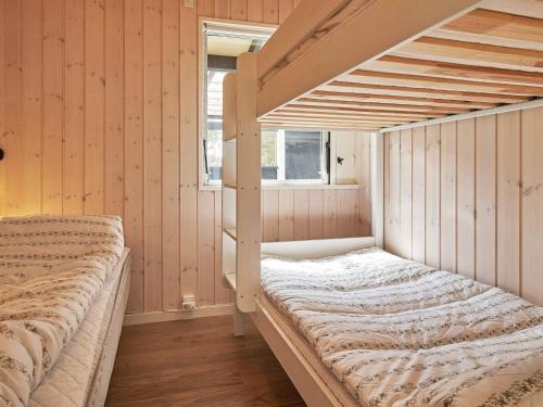 a bedroom with a bunk bed and a window at Holiday home Aakirkeby II in Vester Sømarken