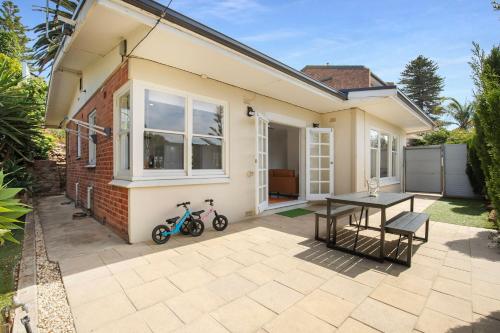 a house with a table and a bike next to it at Relaxing 3BR Beachside Haven Grange in Grange