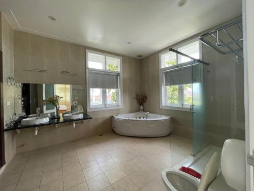 een badkamer met een bad, 2 wastafels en een douche bij Villa Sea View Phan Thiet Mui Ne in Mũi Né