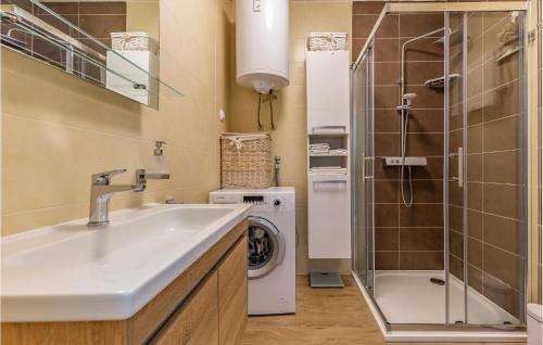 a bathroom with a sink and a washing machine at Stunning Apartment In Medulin With Wifi in Medulin