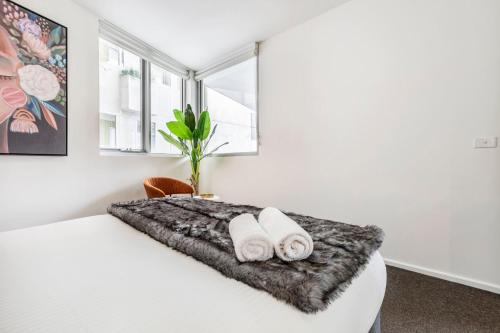 a bedroom with a bed with two towels on it at In the heart of Richmond - 1693 in Melbourne