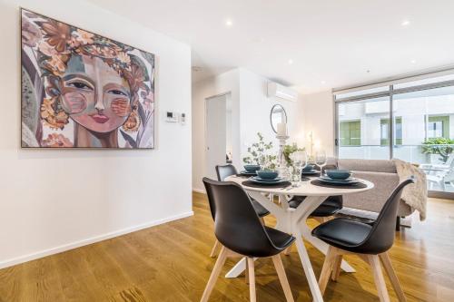 a dining room with a table and chairs and a painting at In the heart of Richmond - 1693 in Melbourne