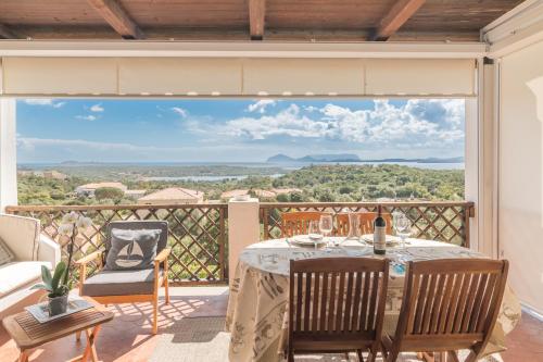 stół i krzesła na balkonie z widokiem w obiekcie La Casa Di Farina With Pool Houses - Happy.Rentals w mieście Porto Cervo