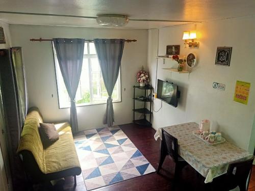 een woonkamer met een tafel en een raam bij Rania Lovely Hut Homestay Kundasang in Kampong Kundassan