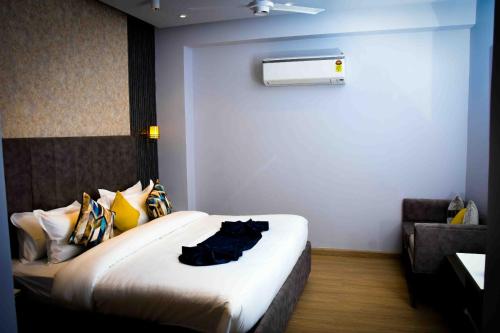 a hotel room with a bed with a robe on it at Hotel Azul Ganga in Rishīkesh