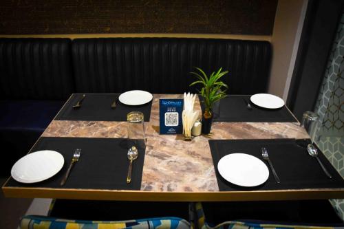 a table with white plates on top of it at Hotel Azul Ganga in Rishīkesh