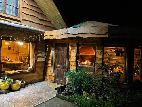 una cocina exterior de una cabaña de madera con plantas en Valle el Abra Ralún Lodge en Puerto Varas