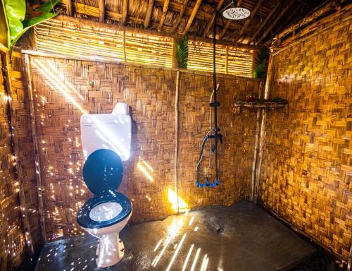 a bathroom with a toilet in a brick wall at Omo Bugamo Skeleton Tribe Eco Resort 