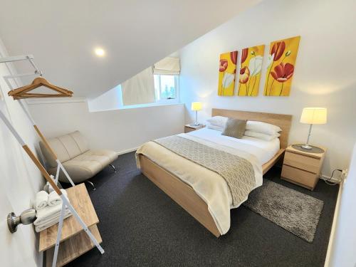 um quarto com uma cama grande e uma cadeira em Spacious 4 BR and 2 Bathrooms City Apartment em Adelaide