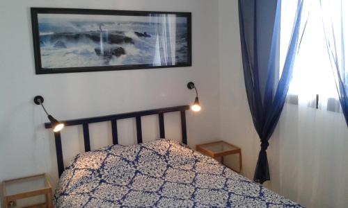 une chambre avec un lit avec deux lampes et une fenêtre dans l'établissement Appartement Carnon Plage, à Carnon-Plage