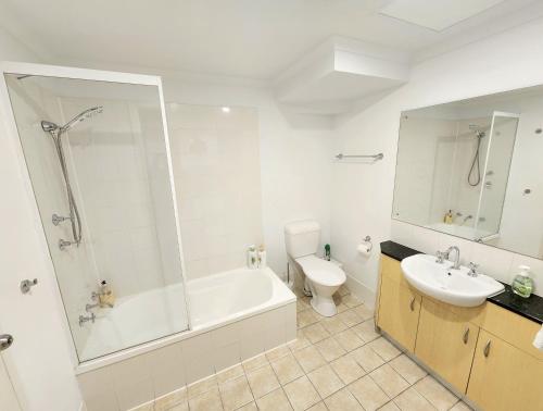 La salle de bains est pourvue d'une baignoire, de toilettes et d'un lavabo. dans l'établissement Spacious 4 BR and 2 Bathrooms City Apartment, à Adélaïde