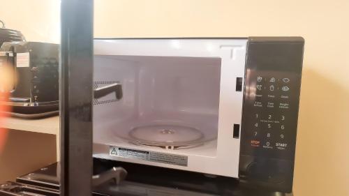 a microwave oven with its door open on a shelf at Room in Guest room - Newly Built Private Ensuite In Dudley Westmidlands in Dudley