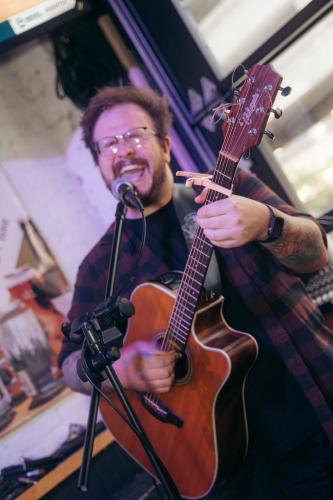 a man holding a guitar and a microphone at The Cambie Hostel Seymour in Vancouver