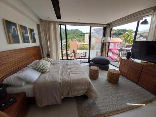 a bedroom with a large bed and a flat screen tv at Mako 54 in Puerto Vallarta